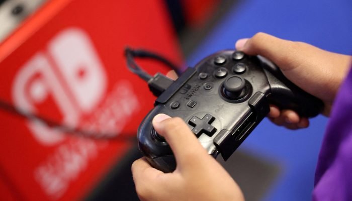 Público usa um console de videogame Nintendo Switch enquanto joga um videogame na Paris Games We...