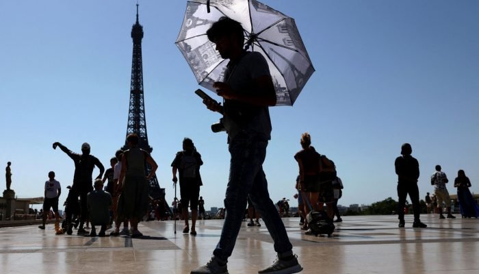 Turista se protege do calor em Paris 1/7/2025 REUTERS/Tom Nicholson