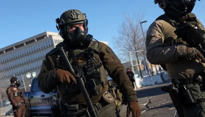 Agentes da lei fazem segurança enquanto manifestantes protestam em frente ao Edifício Federal B...