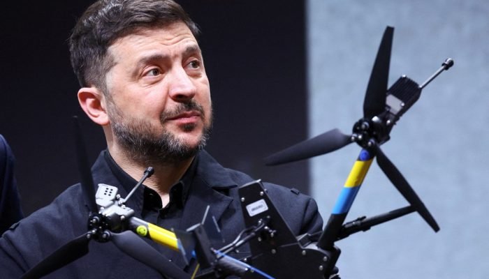 O presidente da Ucrânia, Volodymyr Zelenskiy, reage ao ser fotografado atrás de um drone durant...
