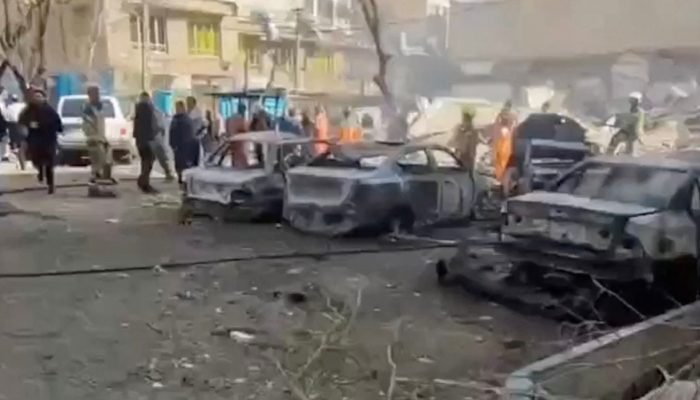 Pessoas se reúnem próximo a veículos queimados em Teerã, Irã, neste frame obtido de vídeo e...