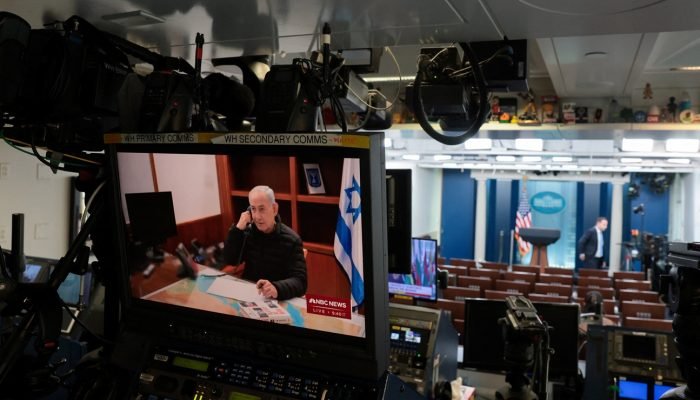 Um monitor de televisão exibe o primeiro-ministro israelense Benjamin Netanyahu na, de resto, va...