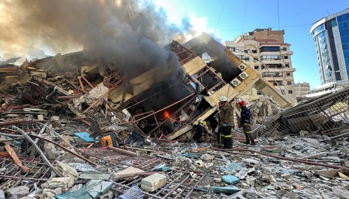 9 de março de 2026 - Membros da Defesa Civil do Líbano inspecionam escombros de prédio atingid...