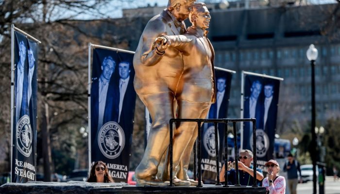 Pessoas observam uma estátua que retrata o presidente dos EUA, Donald Trump, e o criminoso sexua...