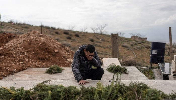 23 de março de 2026 - Abbas Tahhan, 19, chora sobre o túmulo de seus pais e irmão, mortos em u...