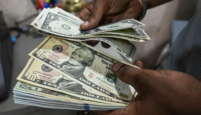 Um funcionário conta notas de dólar americano em uma casa de câmbio em Nova Délhi, Índia, no...