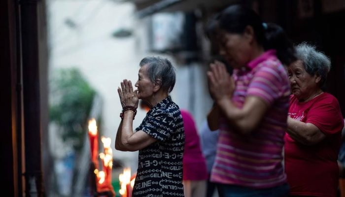 78555166_This-picture-taken-on-August-25-2018-shows-women-praying-in-an-alley-at-the-back-of-the
