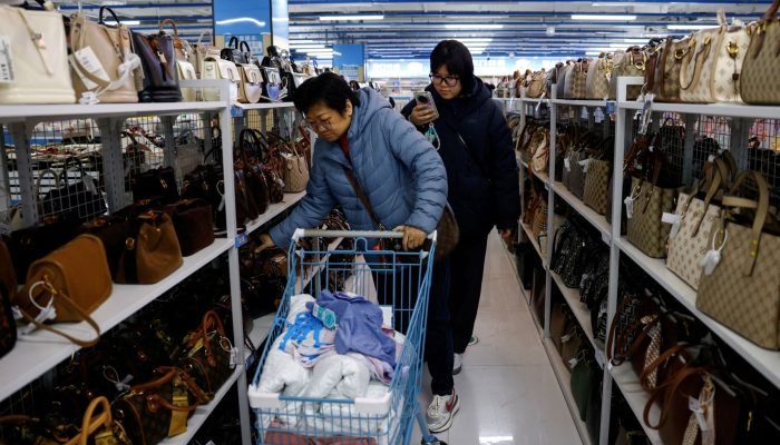 Clientes compram bolsas na loja Wankelai em Pequim, China (Foto: REUTERS/Tingshu Wang)