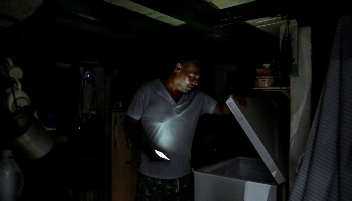 Um homem usa a luz do seu celular para iluminar sua cozinha durante apagão em Cuba - 10/09/2025 ...