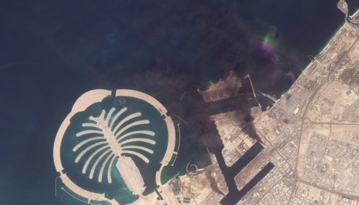 Uma imagem de satélite do Porto de Jebel Ali após um dos berços pegar fogo devido a destroços...
